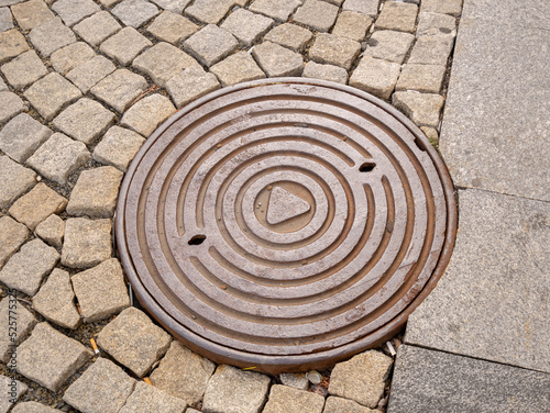 Metal hatch on paving stones.