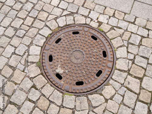 Metal hatch on paving stones.