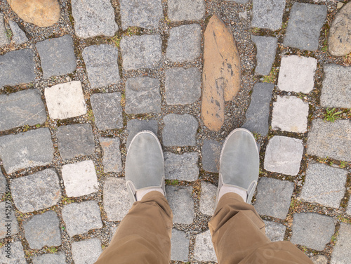 Feet on the paving stones in the square.