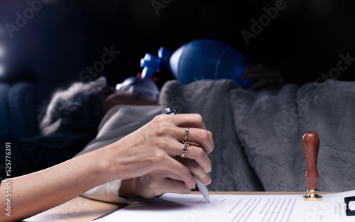 Elderly senior person was force hand, manipulate to sign stamp on Last Will document. Cancer health Patient sign on inheritance finance life insurance real estate contract to lawyer, copy space