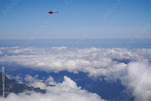 Helicóptero rojo  sobrevolando cielo nublado