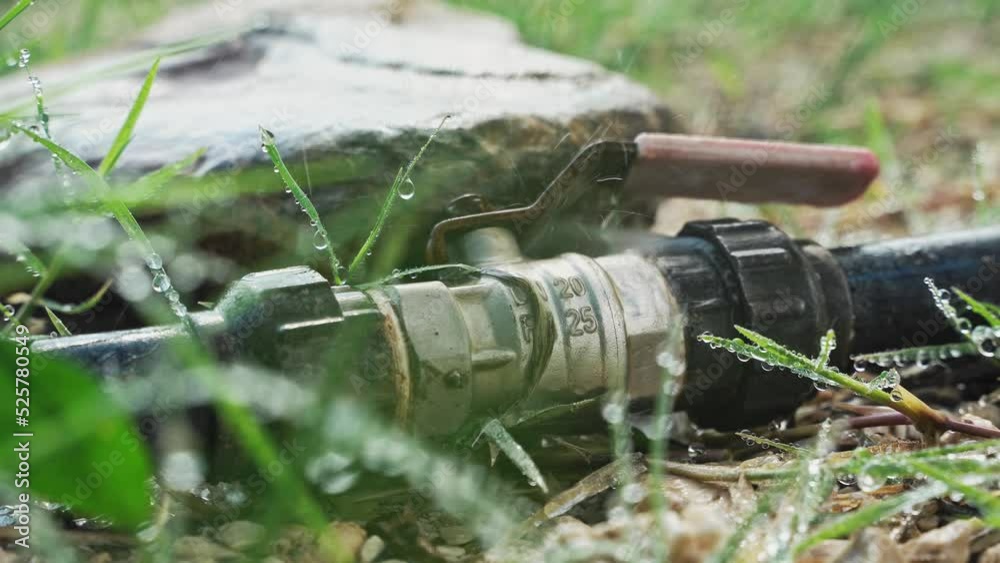 Water flows out of the metal connecting joint between the rubber hoses with water close-up. Water flows from the connecting points of hydraulic structures. Water flows out of the metal connecting joint between the rubber hoses with water close-up. Water flows from the connecting points of hydraulic structures.