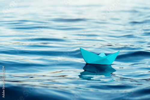 paper boat sails on the blue sea, origami boat on beautiful waves