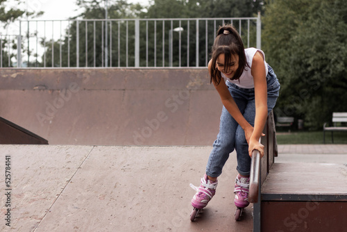 Portrait of a girl learning to inline skates on the playground. photo