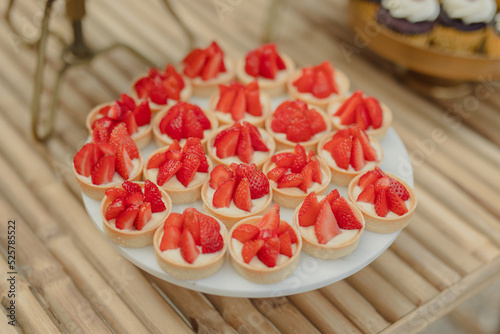 mini cakes with fresh strawberries on a wedding buffet photo