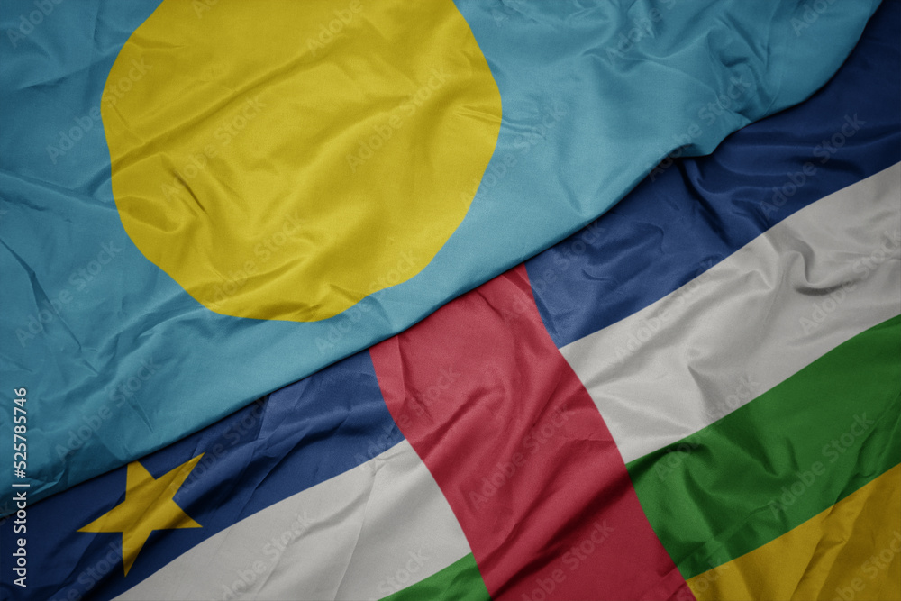 waving colorful flag of central african republic and national flag of Palau .