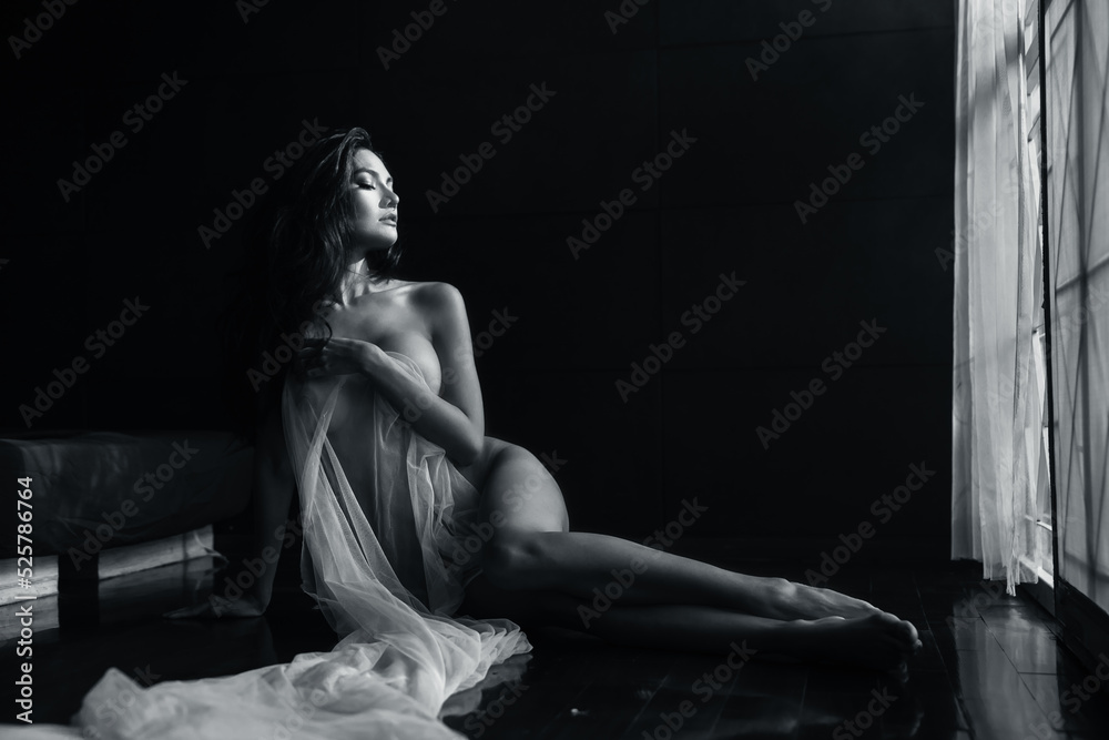 black and white young asian women model sitting poses naked by the window light only a thin curtain envelops her and dark background, lady sexy emotion of art