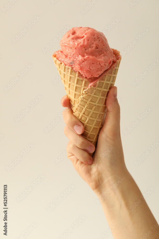 Woman holding waffle cone with delicious pink ice cream on white background, closeup Woman holding waffle cone with delicious pink ice cream on white background, closeup