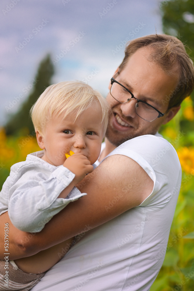 happy fatherhood in the sunflower field. son and father with glasses happy fatherhood in the sunflower field. son and father with glasses