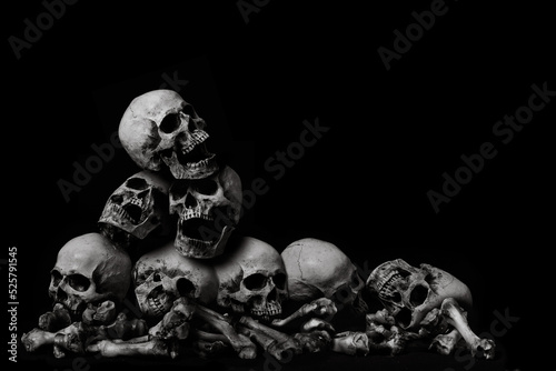 Awesome pile of skull human and bone on wooden, black cloth background, concept of scary crime scene of horror or thriller movies,Halloween theme, Still Life style, selective focus,
