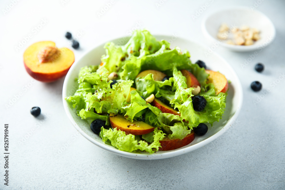 Healthy leaf salad with peach and blueberry