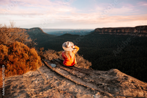 Woman looks out over the mountains in the late afternoon sun