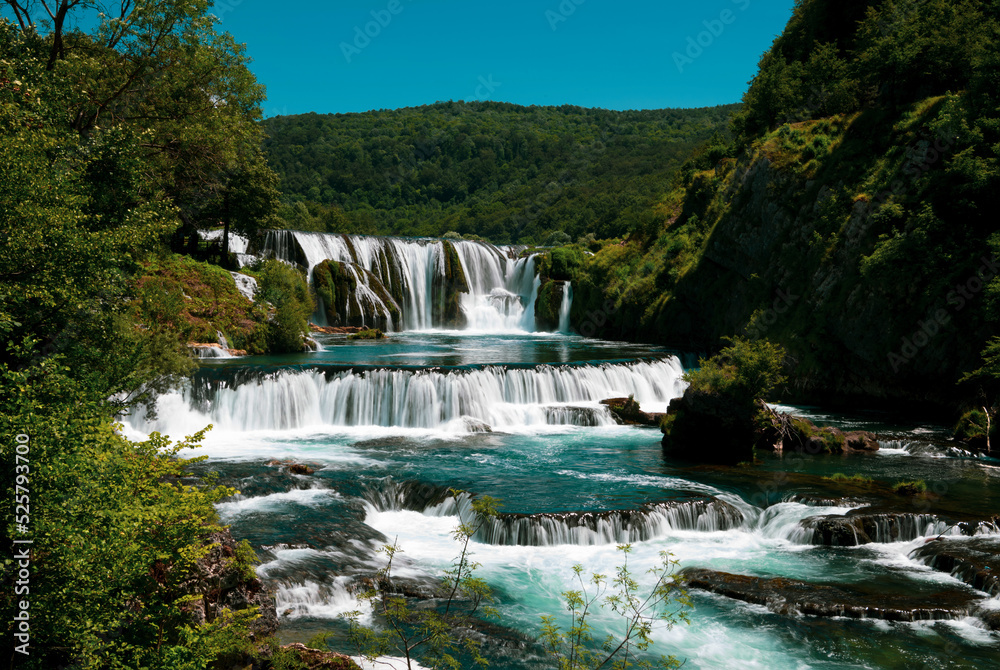 Obraz premium a magnificent waterfall called strbacki buk on the beautifully clean and drinking Una river in Bosnia and Herzegovina in the middle of a forest.