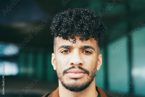 Young latin man looking at camera outdoor - Focus on face