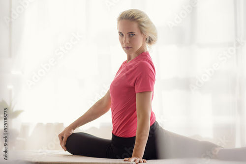 Portrait of young athletic girl doing stretching exercise for legs