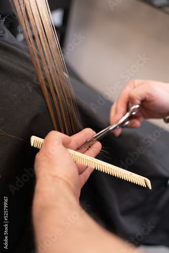 cutting hair in salon close up scissors and hairbrush in hands 