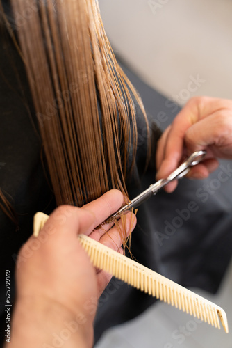 cutting hair in salon close up scissors and hairbrush in hands 