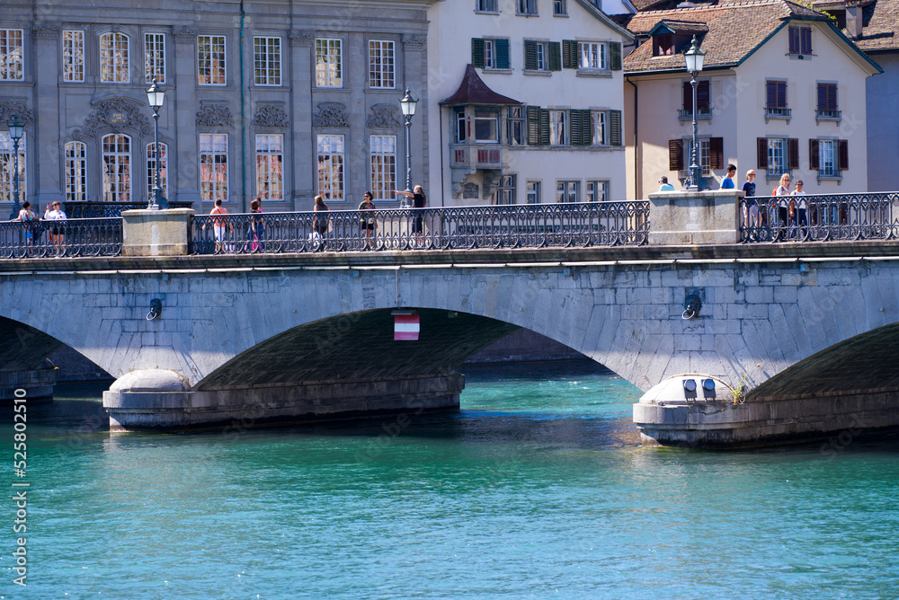 Famous Minster Bridge over River Limmat with guild house in the background at City of Zürich on a sunny summer day. Photo taken July 2nd, 2022, Zurich, Switzerland.