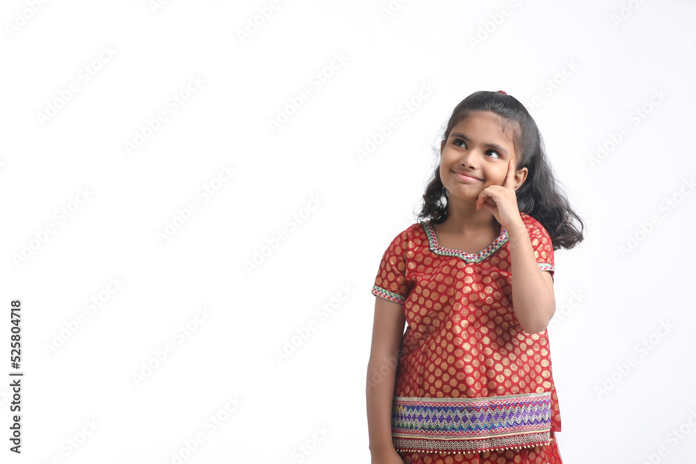 Indian little girl in traditional wear and giving expression on white background.