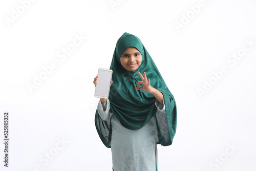 Indian little girl showing smartphone on white background.