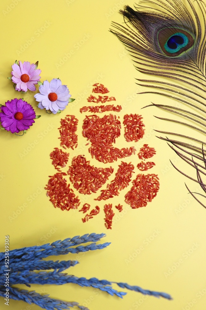 Ganesha art is made with colored rice. Ganesh Chaturthi wallpaper or  banner. Ganpati over yellow and white background along with diya and  flowers. copy space. Stock Photo | Adobe Stock