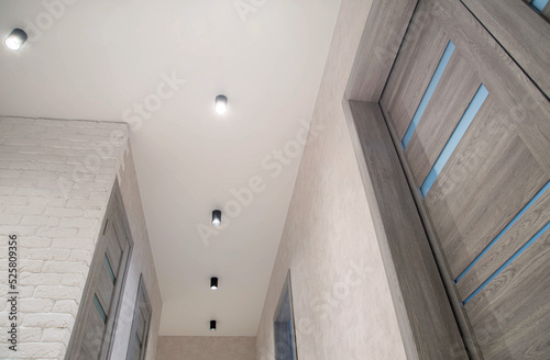 Modern renovation and design in the hallway. Black LED spotlights on the ceiling. New gray interior doors.