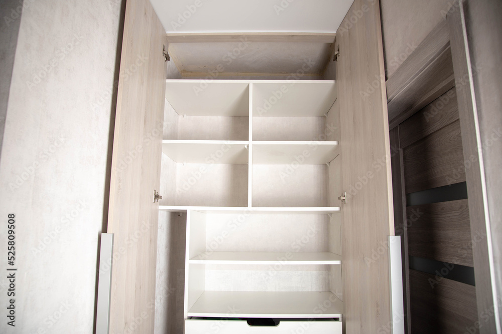 Modern closet in the hallway with hinged doors and pull-out shelves. Production of furniture under the order. Modern closet in the hallway with hinged doors and pull-out shelves. Production of furniture under the order.