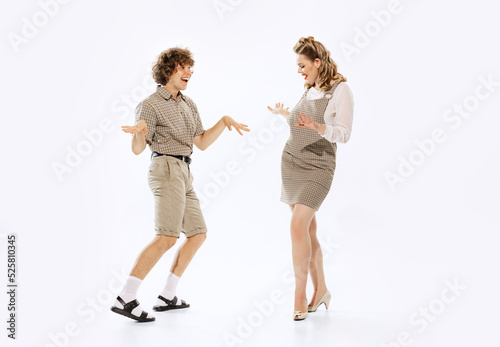 Expressive couple of dancers in vintage retro style outfits dancing social dance isolated on white background. Timeless traditions, 60s ,70s american fashion style.