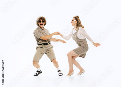 Expressive couple of dancers in vintage retro style outfits dancing social dance isolated on white background. Timeless traditions, 60s ,70s american fashion style.