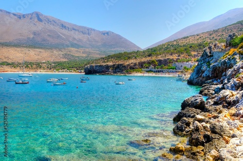 The beautiful Greek coastline with crystal clear waters and many boats anchored near Diros caves in Greece. A stunning scenery, perfect for swimming. photo