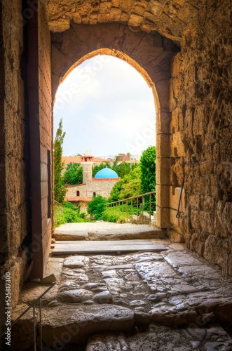 View of the mosque in the historic city of Byblos  Lebanon through the door gate of the crusader castle  a landmark of Jbeil.