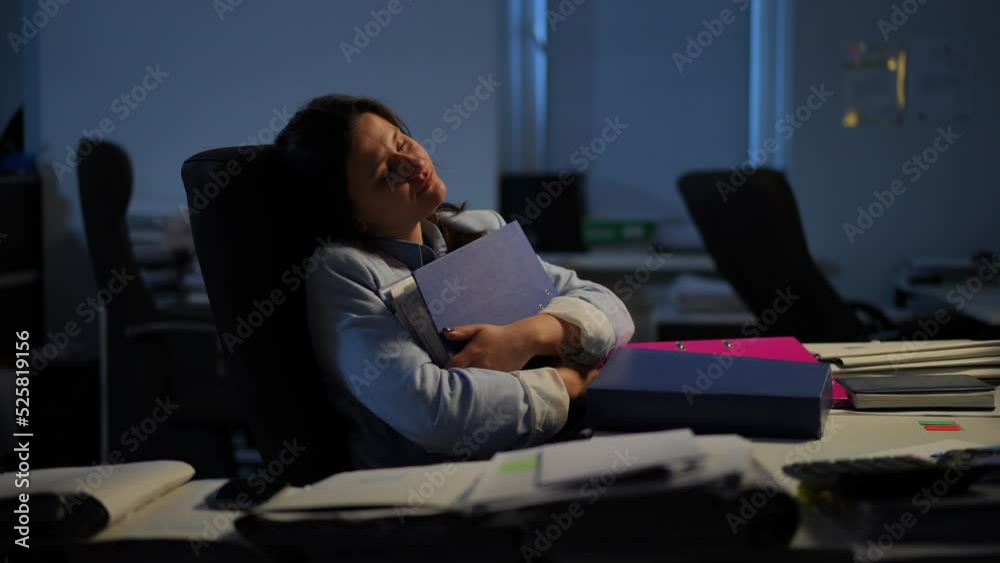Exhausted overworked Caucasian woman yawning sitting in comfortable chair with closed eyes. Portrait of tired businesswoman taking a nap hugging document folder. Multitasking and overworking Exhausted overworked Caucasian woman yawning sitting in comfortable chair with closed eyes. Portrait of tired businesswoman taking a nap hugging document folder. Multitasking and overworking