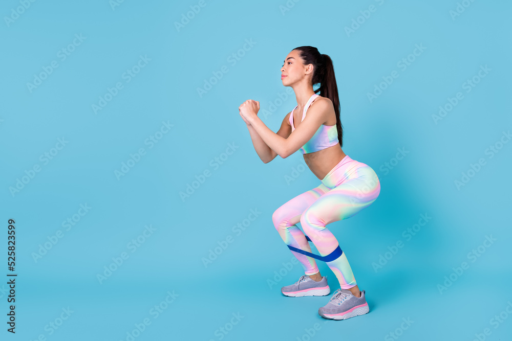 Full body photo of attractive japanese lady do sit ups resistance band dressed trendy sporty outfit isolated on shine blue color background