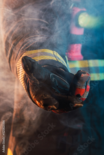 Fireman's hand giving help at fire with smoke.  Night image with flashlight on.