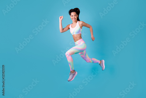 Full length photo of korean girl run hurry sales train maraphon dressed stylish sporty clothes isolated on vibrant blue color background