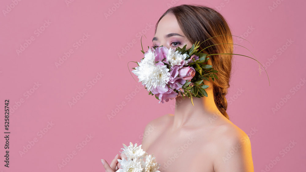 Keep your distance and use protection in the spring, seasonal exacerbation of viral infections and allergies. Young woman in floral face mask, portrait in studio on pink background Keep your distance and use protection in the spring, seasonal exacerbation of viral infections and allergies. Young woman in floral face mask, portrait in studio on pink background