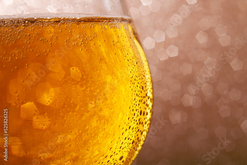 Beer in a pub or bar. Beer in a glass on a shiny background. Frothy cold drink.