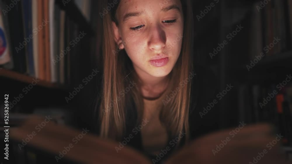 Girl in library between the bookshelves and reading book aloud for finding information. Spend time in literature storage to gain new knowledge. Interesting work from school literature. Girl in library between the bookshelves and reading book aloud for finding information. Spend time in literature storage to gain new knowledge. Interesting work from school literature.