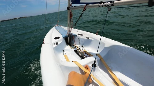 Sailor POV shot while solo sailing dinghy boat in Southern Vietnam on a beautiful sunny day. Relaxing and feeling of freedom.  photo