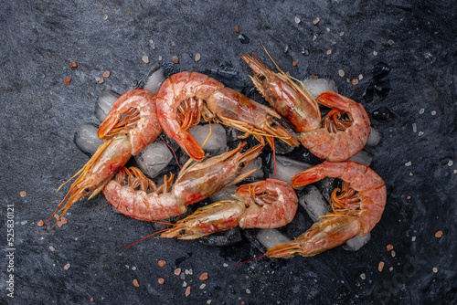 shrimps. wild ocean jumbo shrimps with ice and lemon, seafood shrimps prawns on ice frozen. Long banner format. top view