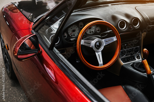 leather interior and sports steering wheel of a red convertible. car exterior © Irina