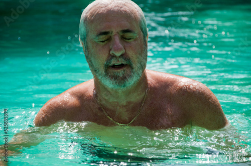 senior man swimming in summer pool on summertime vacation © altana_studio