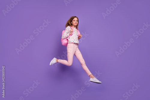 Full length profile photo of charming excited person jumping run rush isolated on violet color background