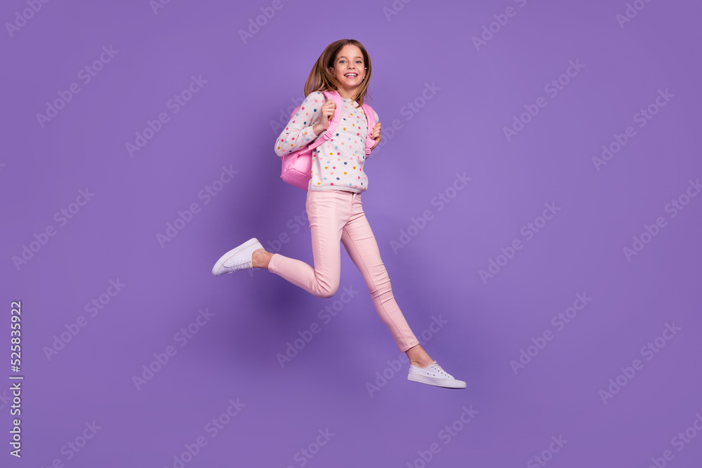Full body photo of crazy carefree girl jump carry backpack have good mood isolated on violet color background