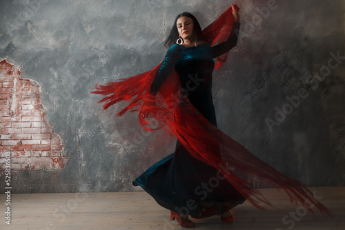 Young adult spanish woman dancing flamenco on gray vintage studio background