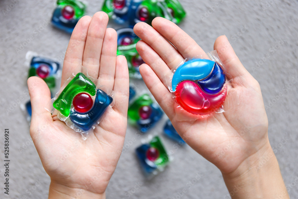 choice of different capsules for washing, capsules with laundry gel in woman hand choice of different capsules for washing, capsules with laundry gel in woman hand
