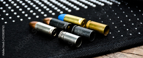 9mm pistol bullets and bullet shells on black leather background, soft and selectivec focus.