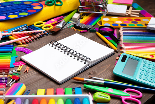 School supplies. Set of colorful school accessories isolated on the brown wooden background. Top view.