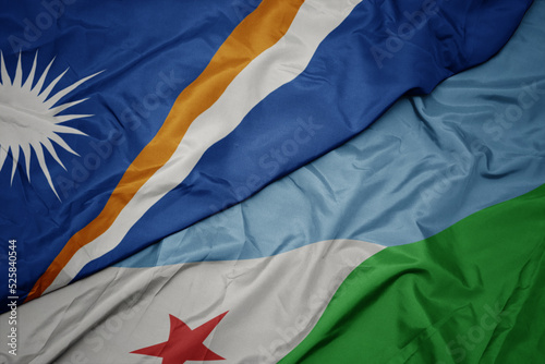 waving colorful flag of djibouti and national flag of Marshall Islands .