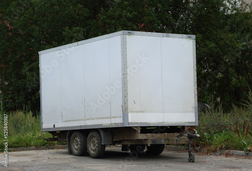 A large white car trailer is parked in the yard, Kollontai Street, St. Petersburg, Russia, August 2022